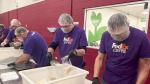 Several people wearing FedEx shirts preparing food at the Food Bank